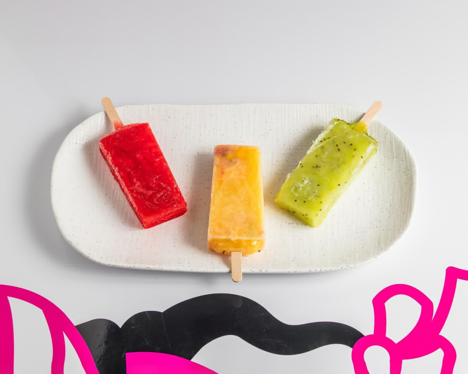 Glace à la fraise avec des tranches de fraises sur une surface grise.