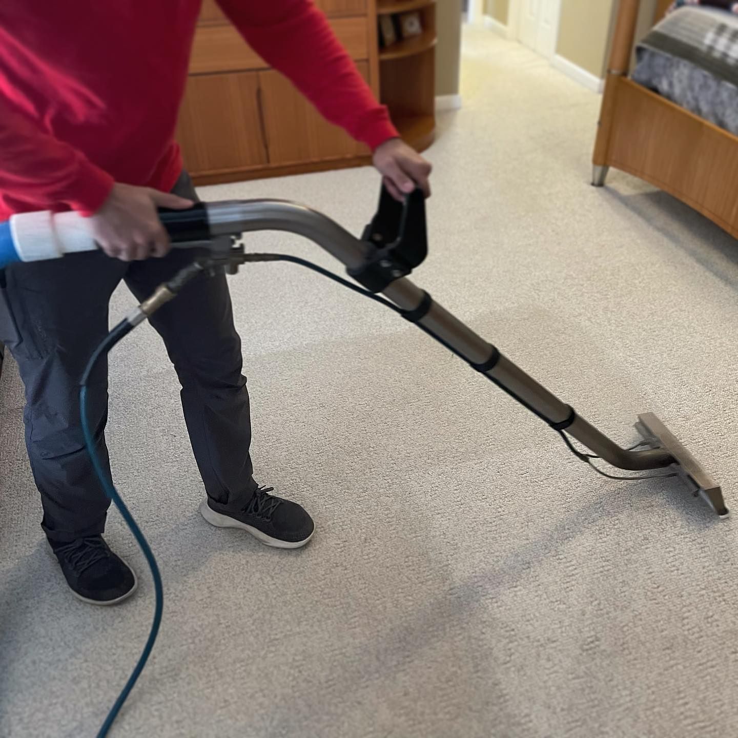 A person is using a vacuum cleaner to clean a carpet