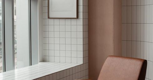 A chair is sitting in front of a window in a room.