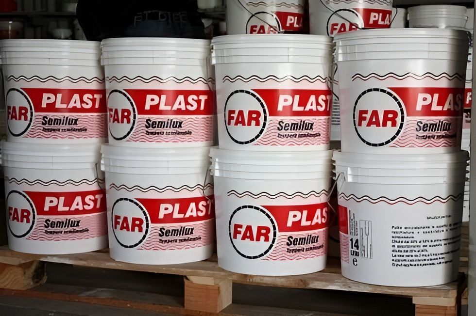 Pile di secchi di vernice bianca FAR PLAST Sensiline su pallet di legno in un magazzino.