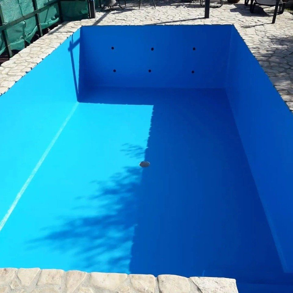 Piscina rettangolare blu vuota in un patio esterno soleggiato