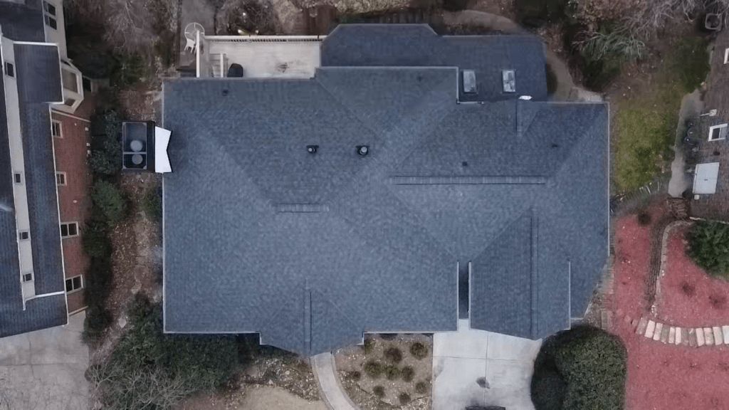 An aerial view of a large house with a gray roof.