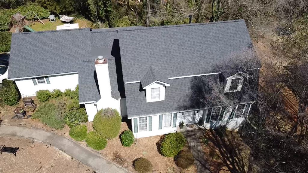 An aerial view of a large white house surrounded by trees.