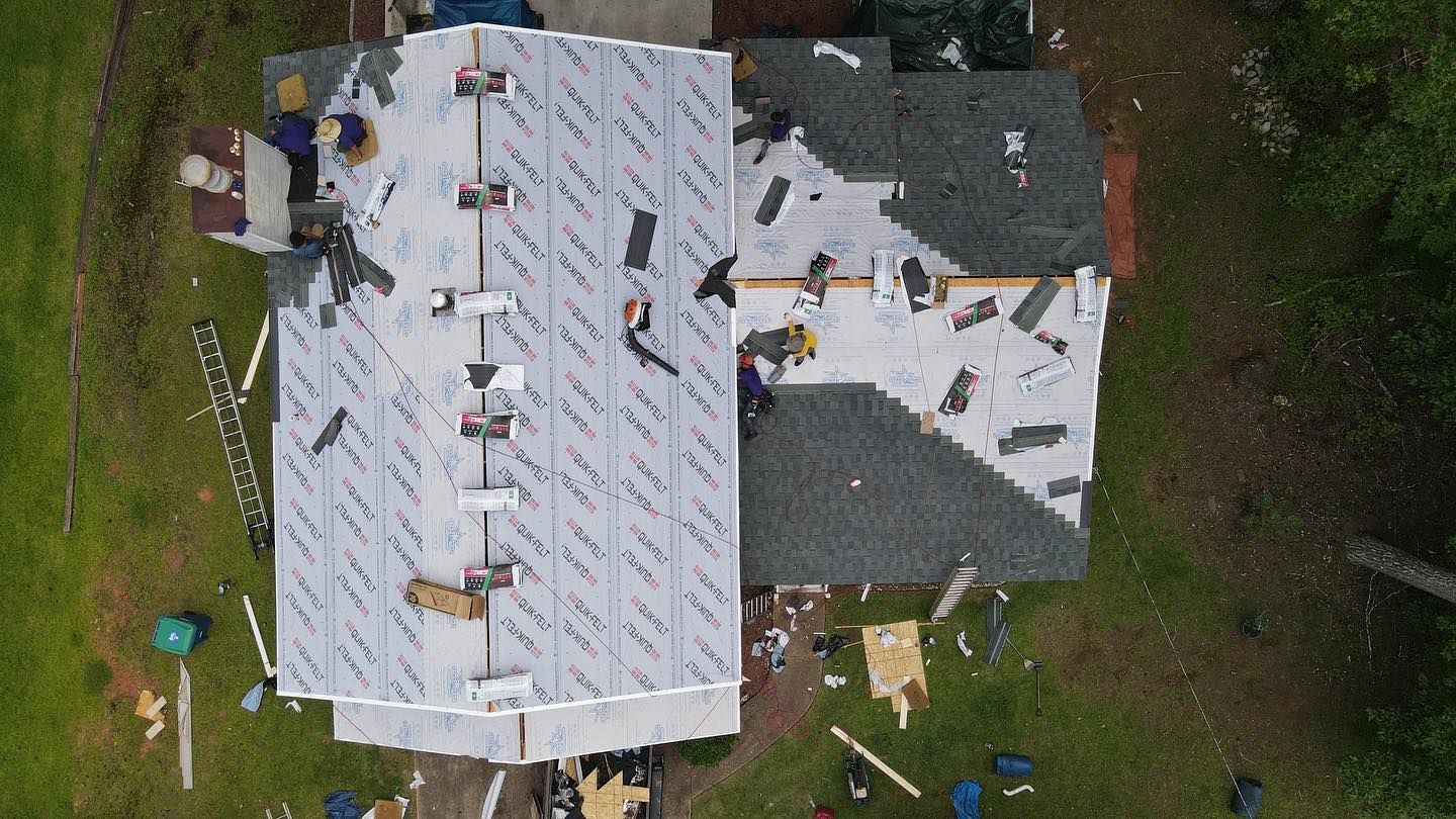 An aerial view of a house being remodeled with a roof being installed.