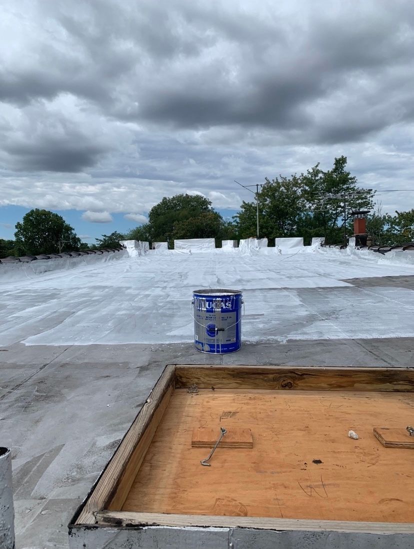 A can of white paint is sitting on top of a roof.