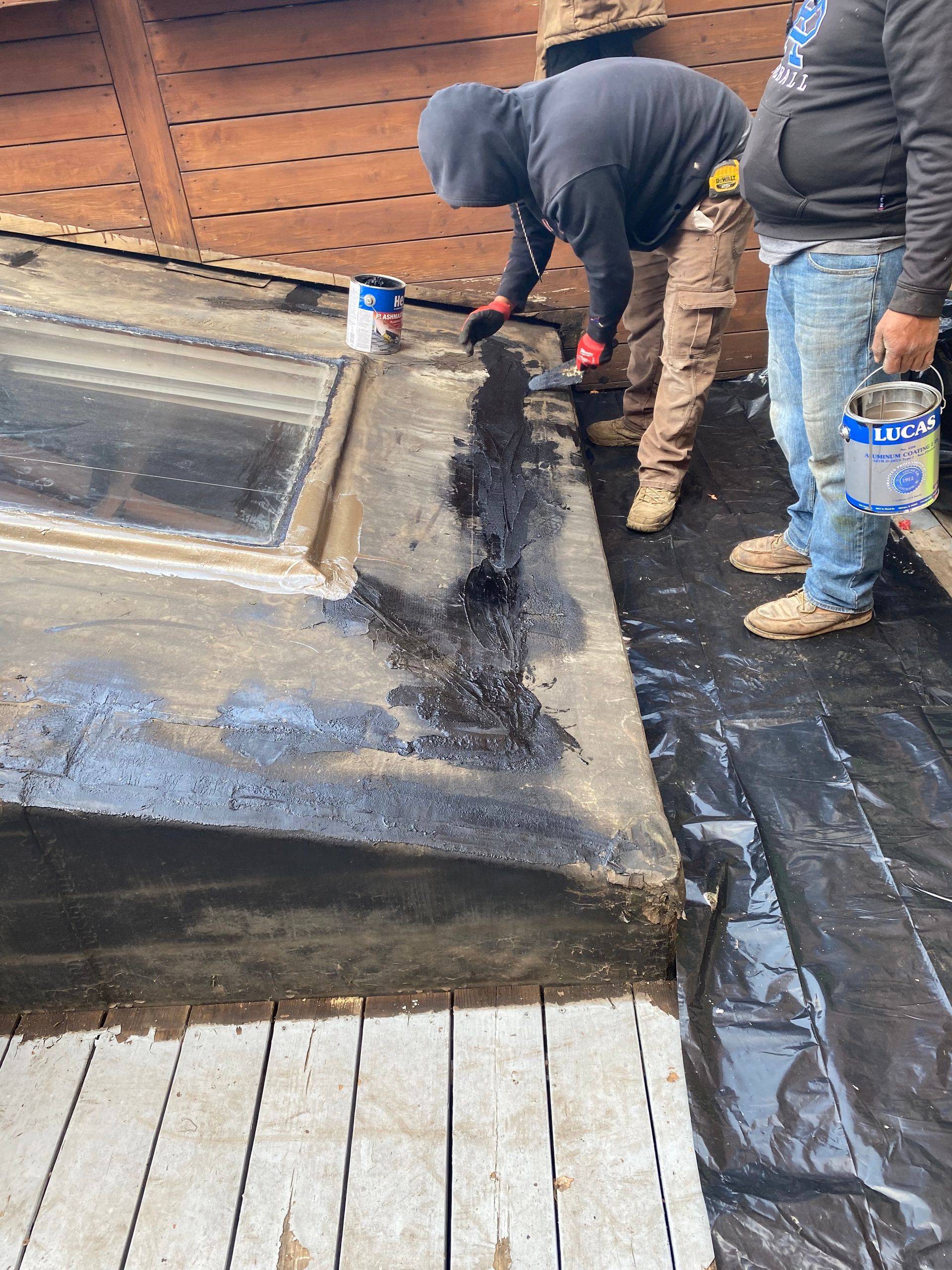 A group of men are working on a roof.