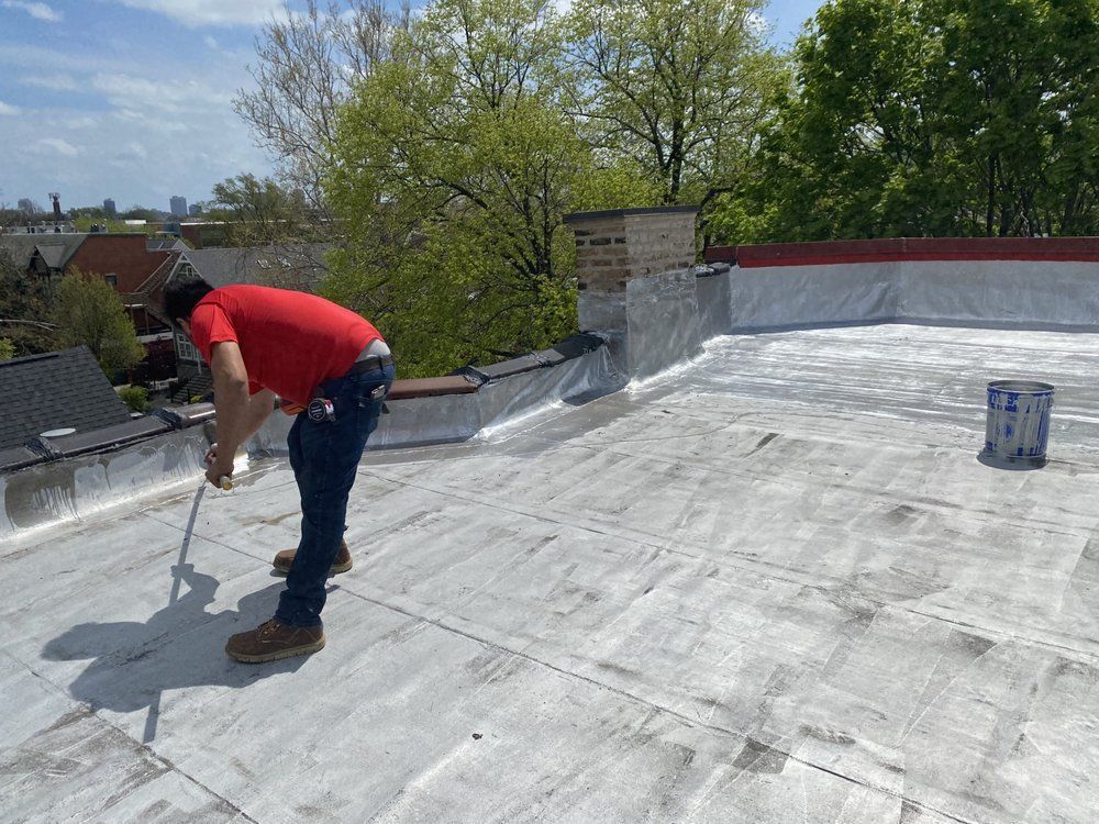A man in a red shirt is cleaning a roof with a brush
