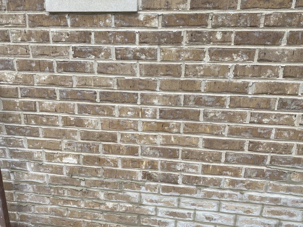 A close up of a brick wall with a sign on it.