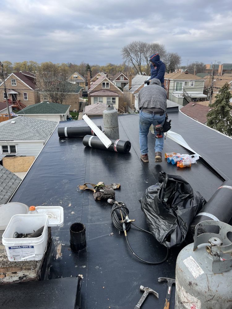 Two men are working on the roof of a house.
