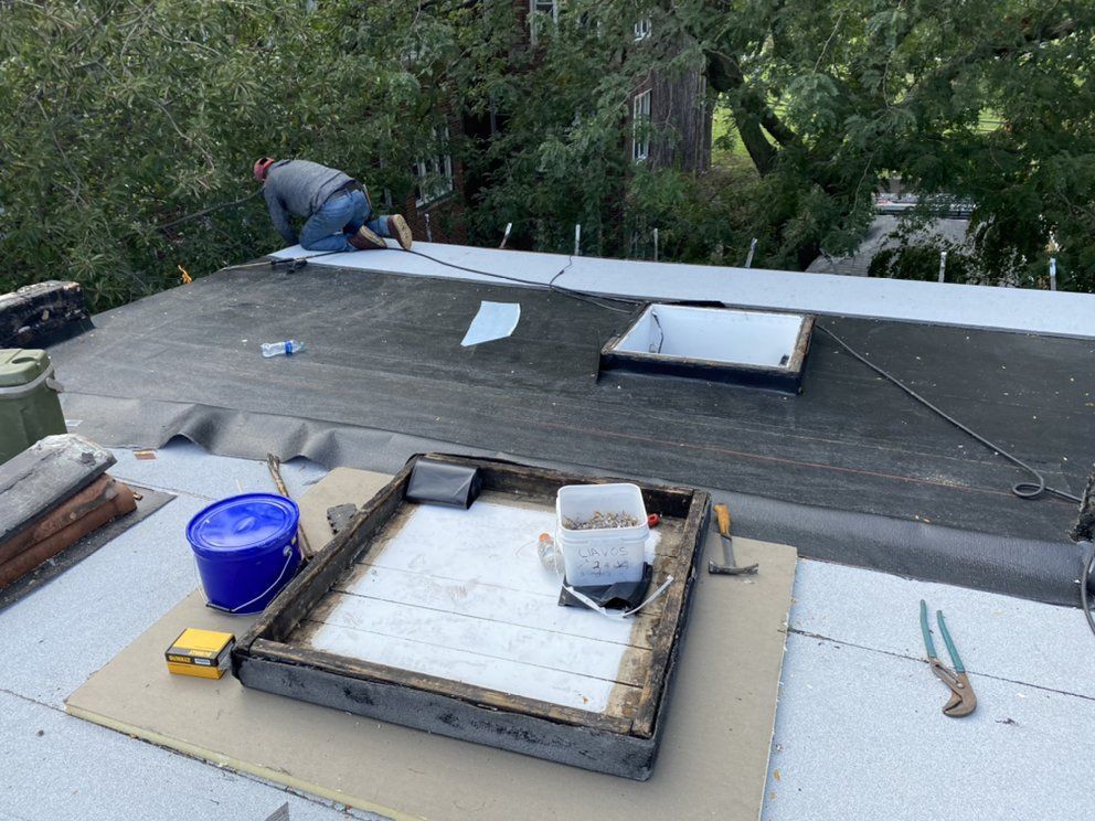 A man is working on the roof of a building.