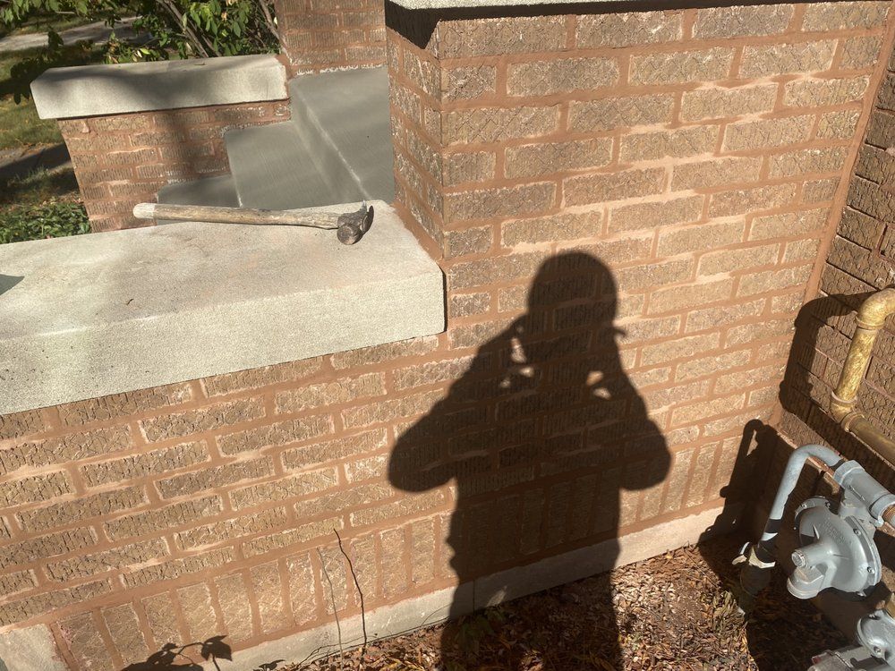A shadow of a person is cast on a brick wall.