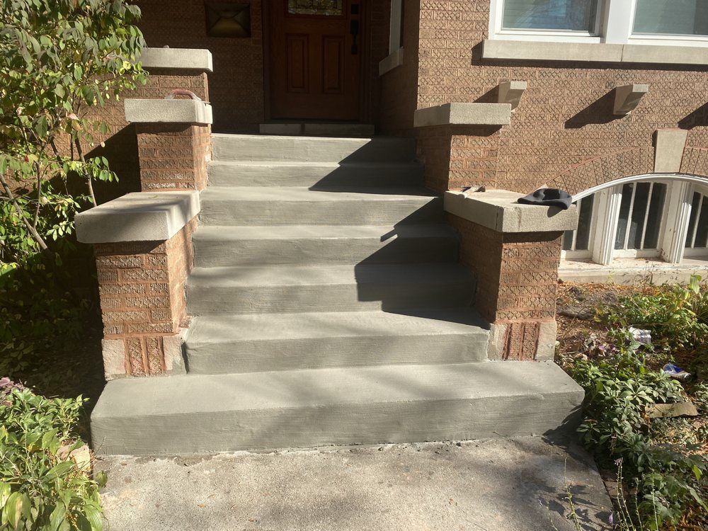 A brick house with concrete steps leading up to the front door