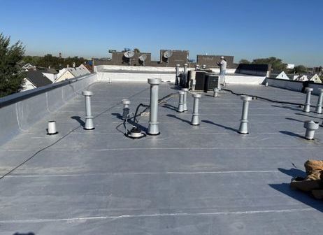 A roof with a lot of pipes on it and a blue sky in the background.