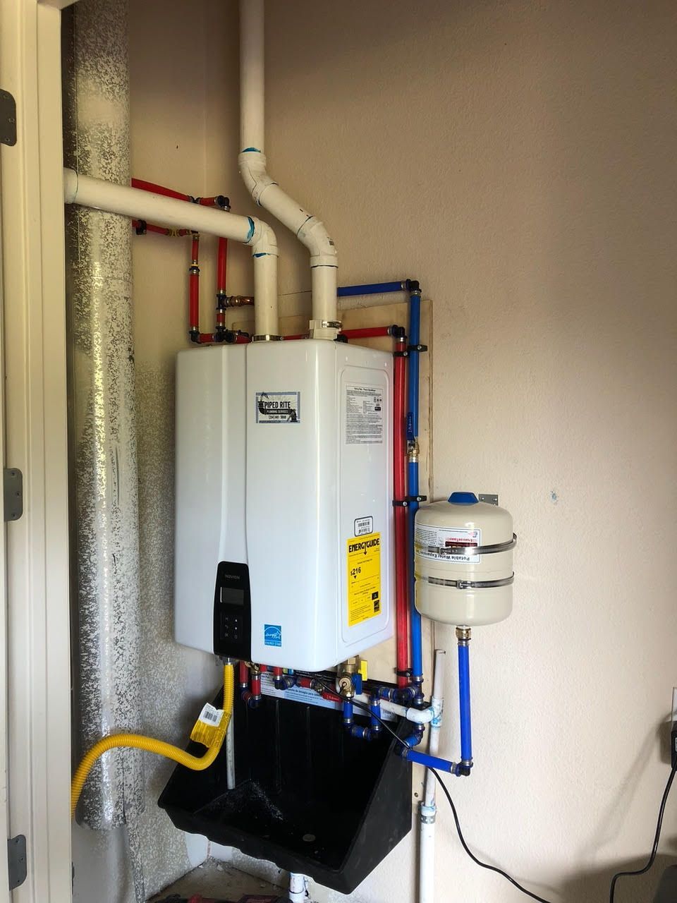 A water heater is mounted to a wall in a room