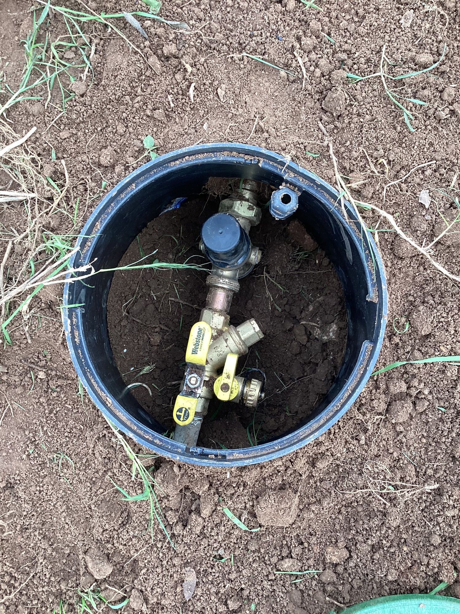 A water meter is sitting in a hole in the ground.