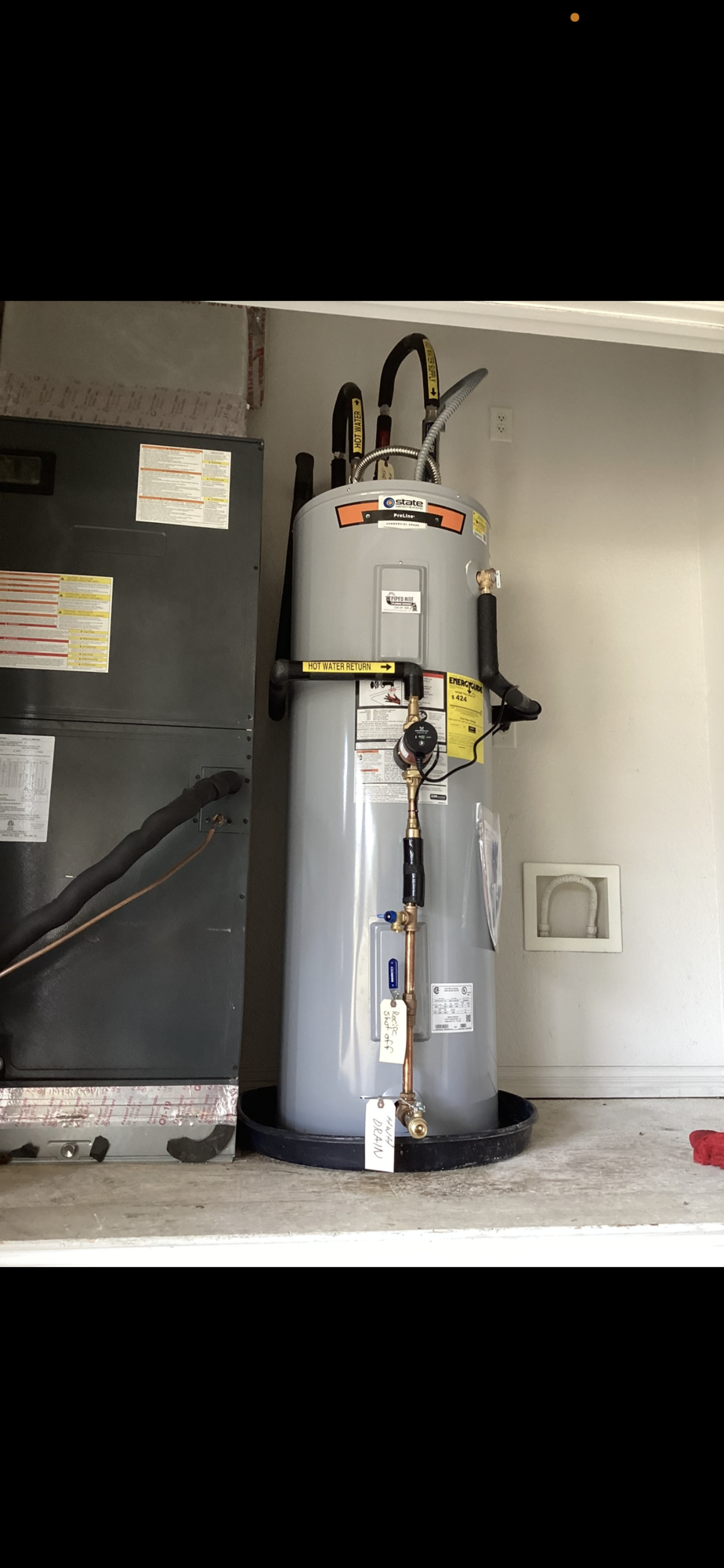 A large water heater is sitting in a garage