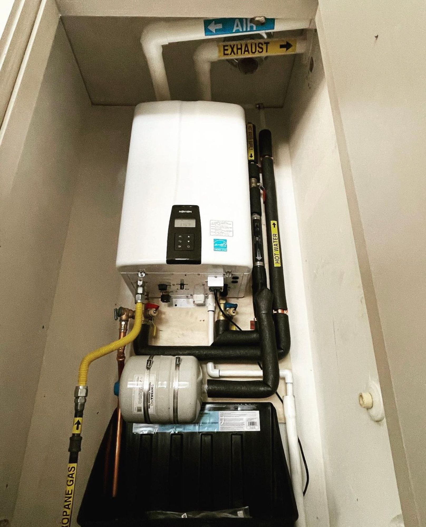 A white boiler with a sign above it that says exhaust