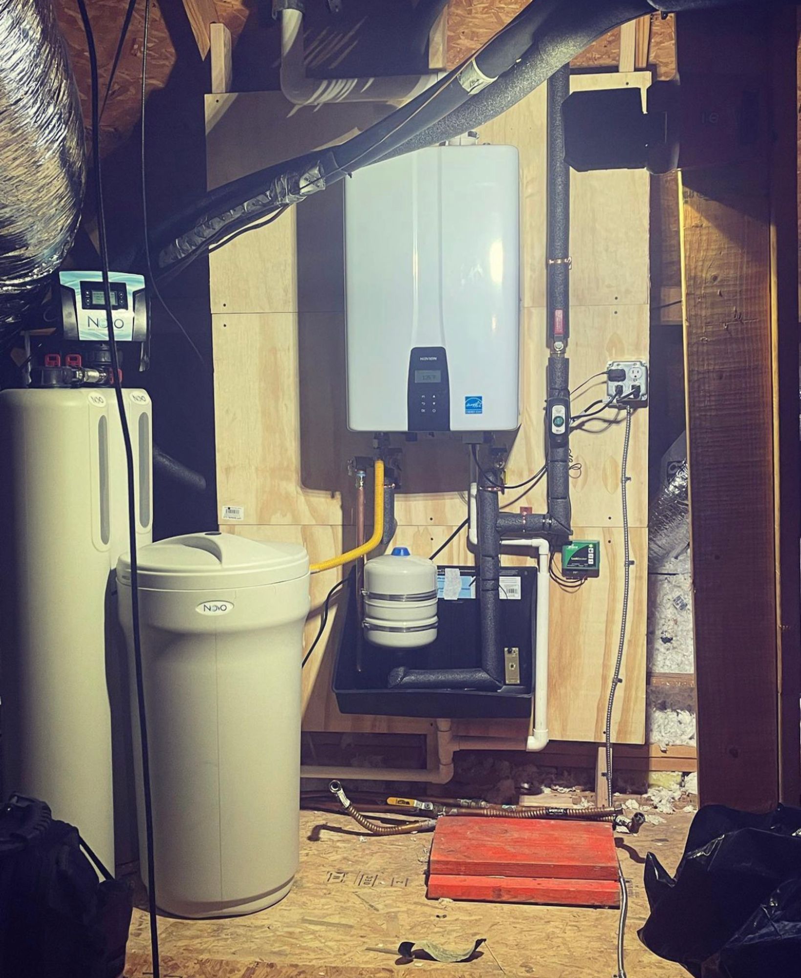 A room with a water heater and a water softener