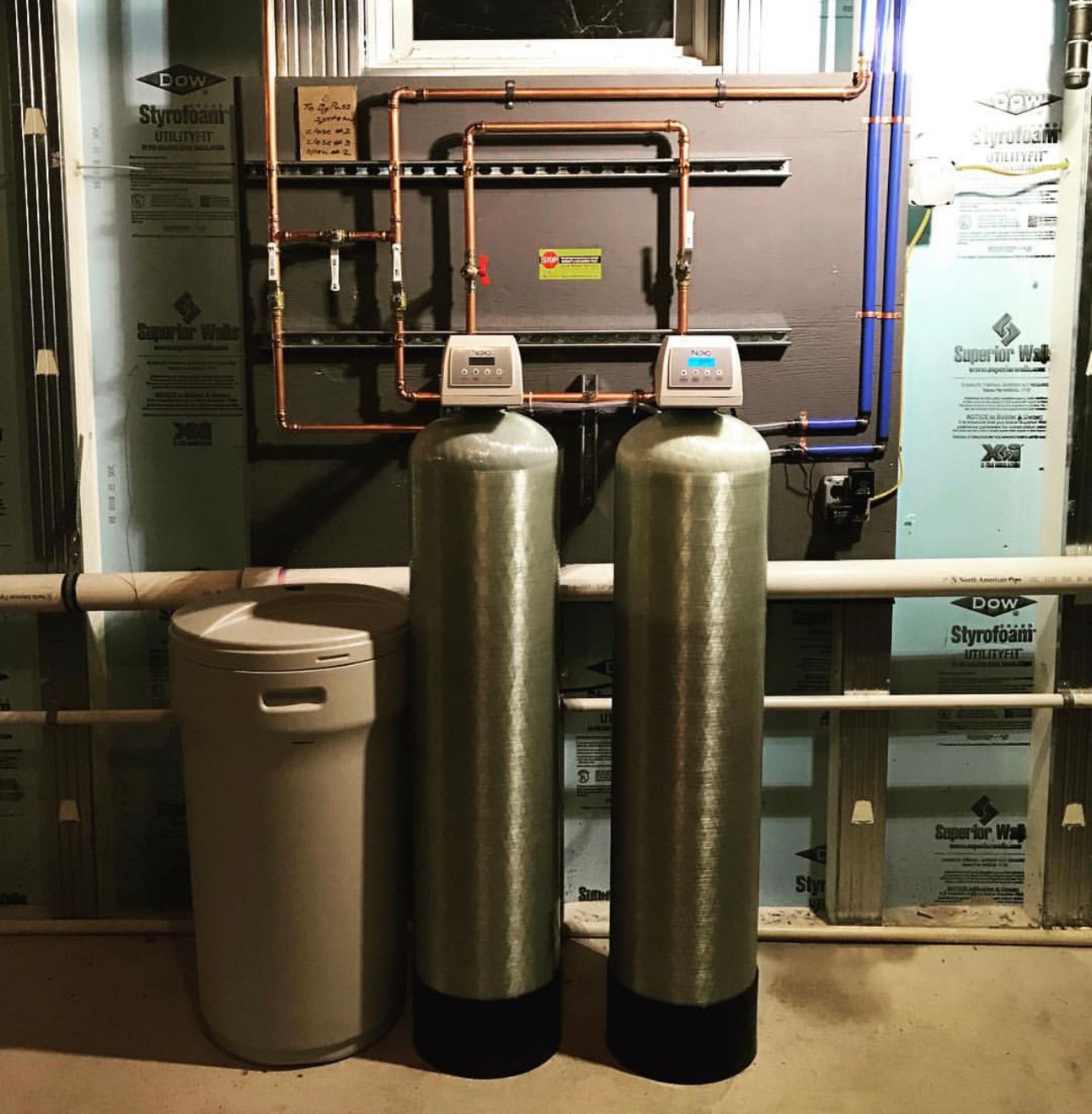Two water filters are sitting next to each other in a room