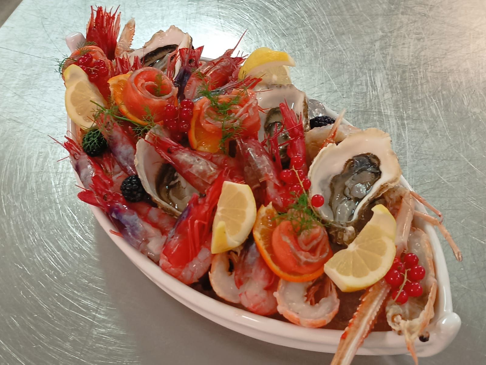 Una ciotola bianca piena di frutti di mare e frutta su un tavolo