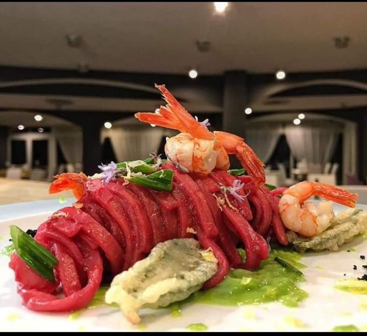 Un primo piano di un piatto di cibo con gamberi e tagliatelle