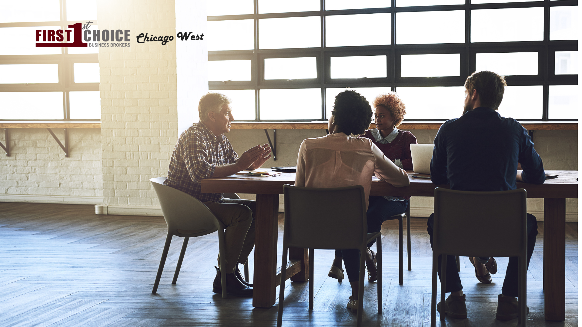 A group of people are sitting around a table having a meeting.