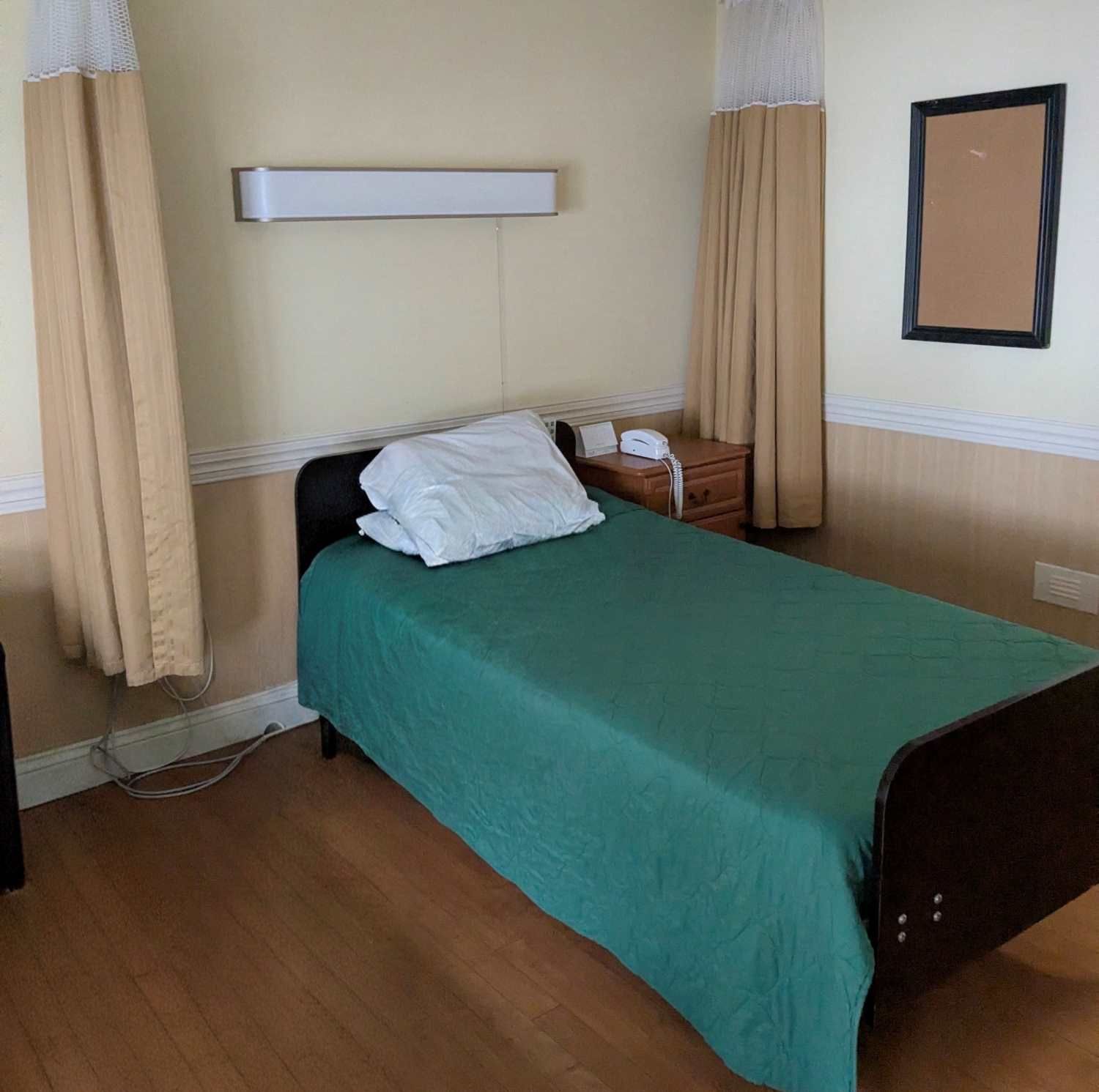 Older institutional-style nursing home resident room with a hospital bed
