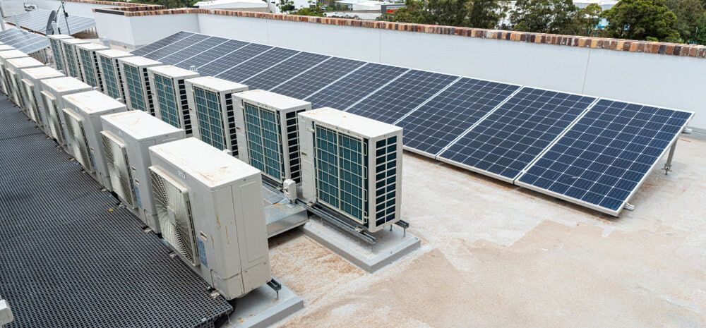 A Row of Air Conditioners and Solar Panels on the Roof of a Building — 888 Solar Tek in Byron Bay, NSW