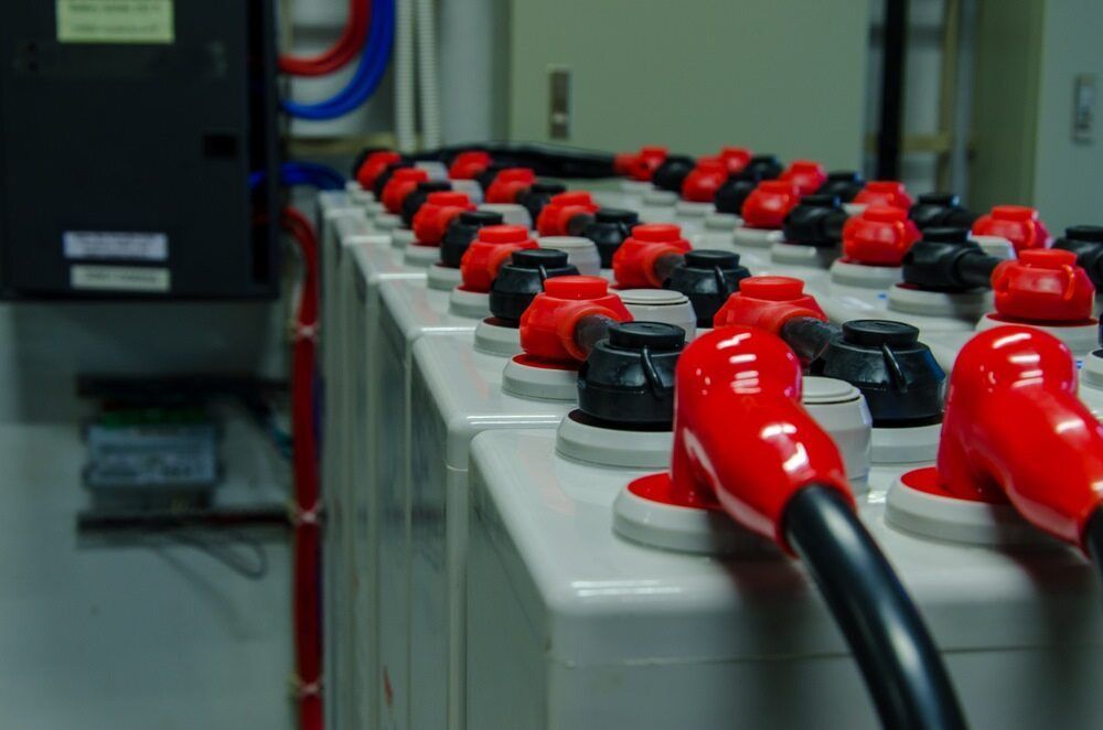 A Row of Batteries With Red Caps Are Lined Up in a Room — 888 Solar Tek in Mullumbimby, NSW