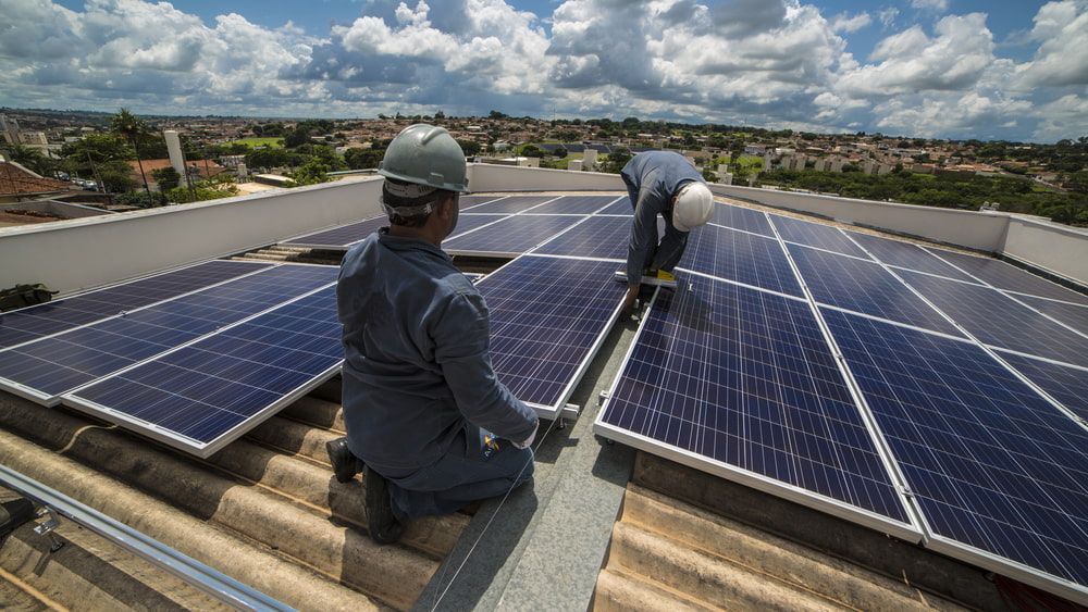 Two Men Are Installing Solar Panels on the Roof of a Building — 888 Solar Tek in Lismore, NSW