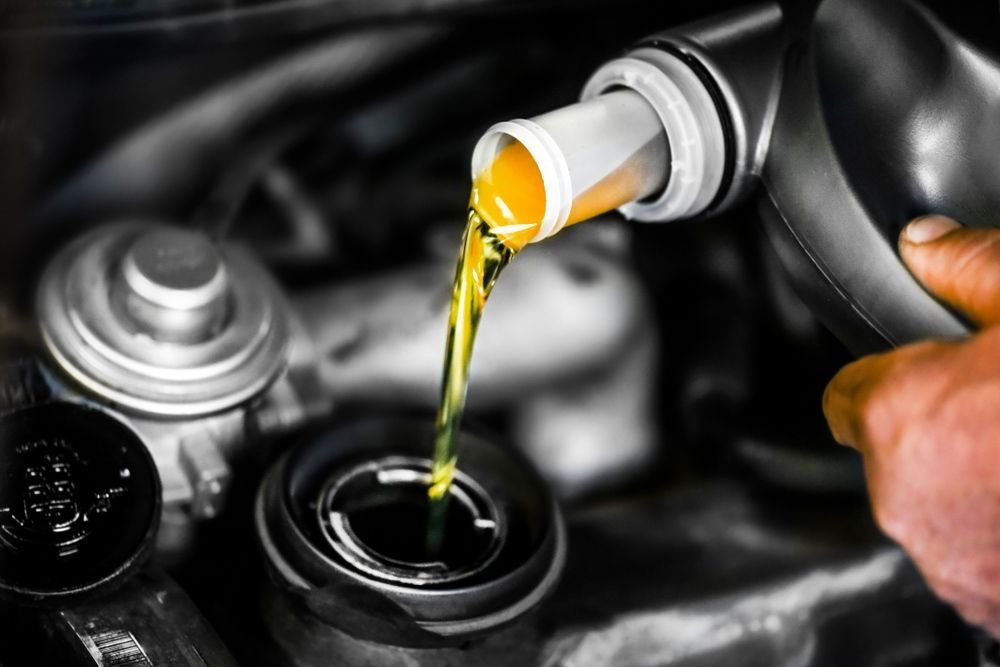 A Person is Pouring Oil Into a Car Engine — Rycam Automotive in Buderim, QLD