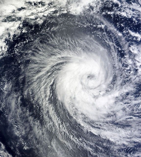 Satellite view of a swirling hurricane over the ocean, with a bright white eye and cloud bands