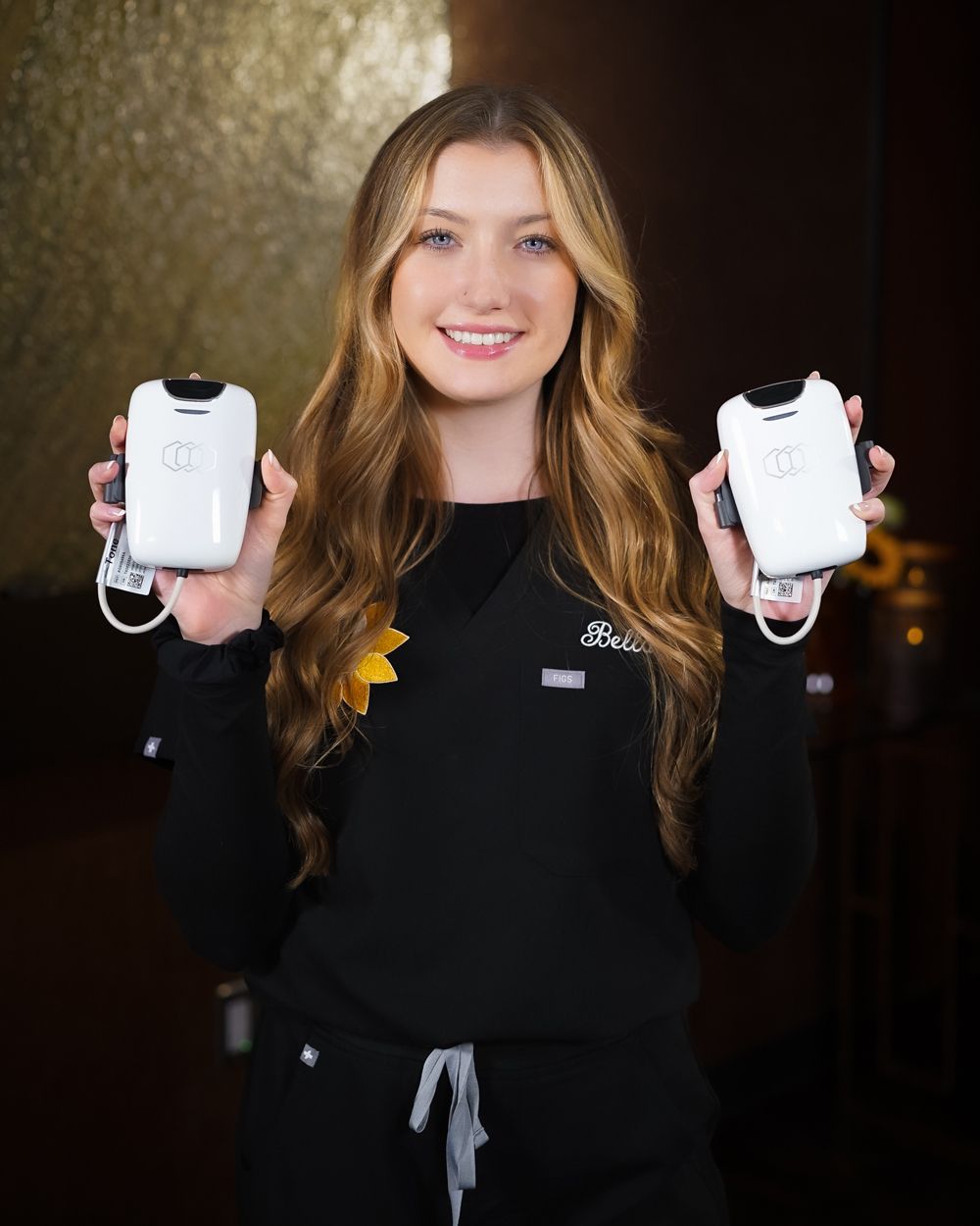 A woman in a black shirt is holding two phones in her hands.