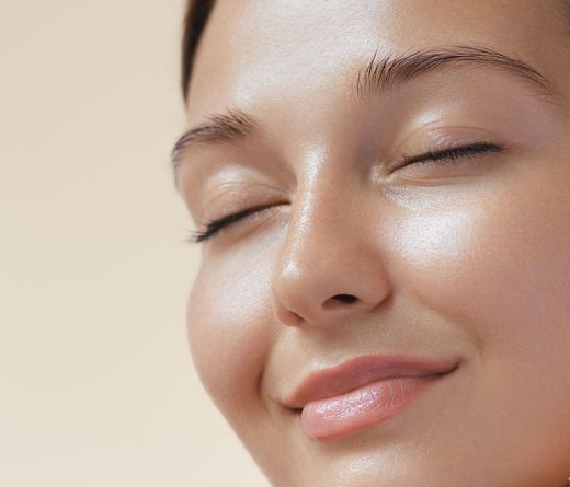 A close up of a woman 's face with her eyes closed.