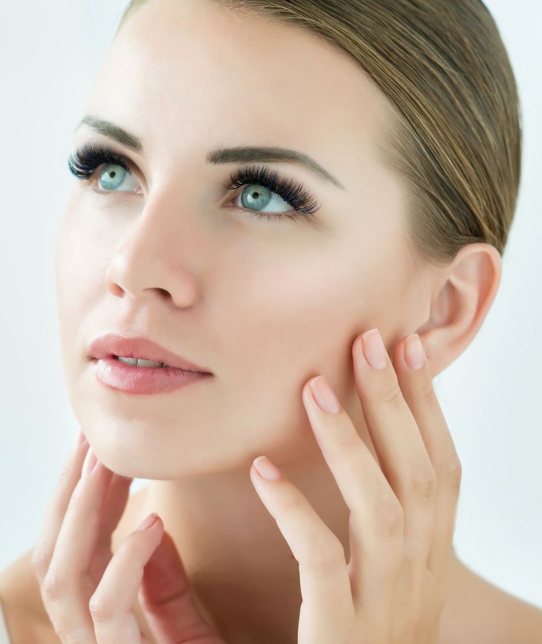 A close up of a woman 's face with her hands on it