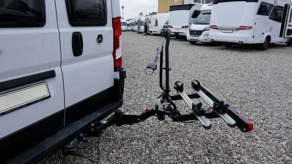 Tow Vehicle Hitch Attached to a Black Bike Rack on Gravel — Dempsters Caravan & RV in Gin Gin, QLD