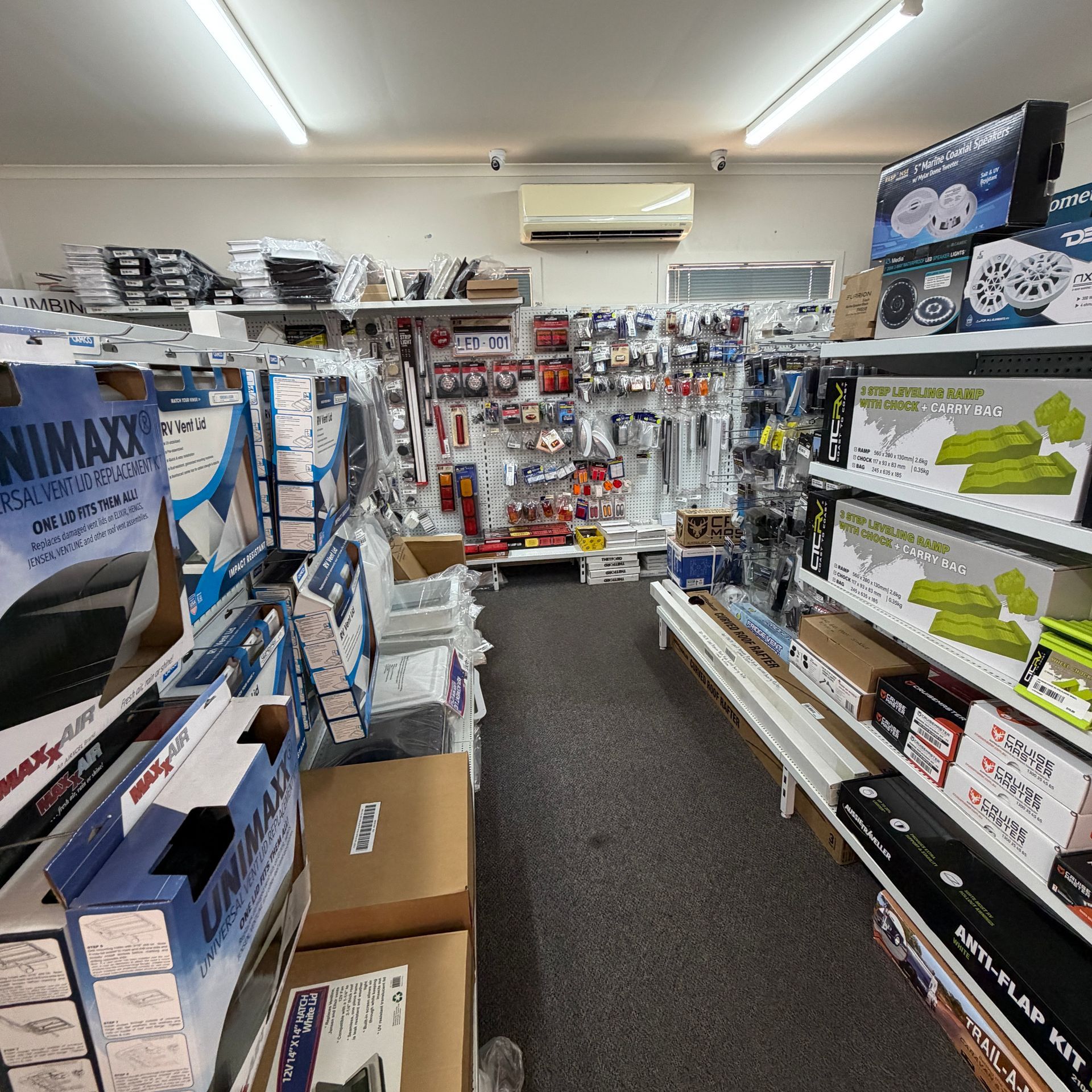 A Narrow Electronics Store Aisle Filled With Boxed Products — Dempsters Caravan & RV in Gin Gin, QLD