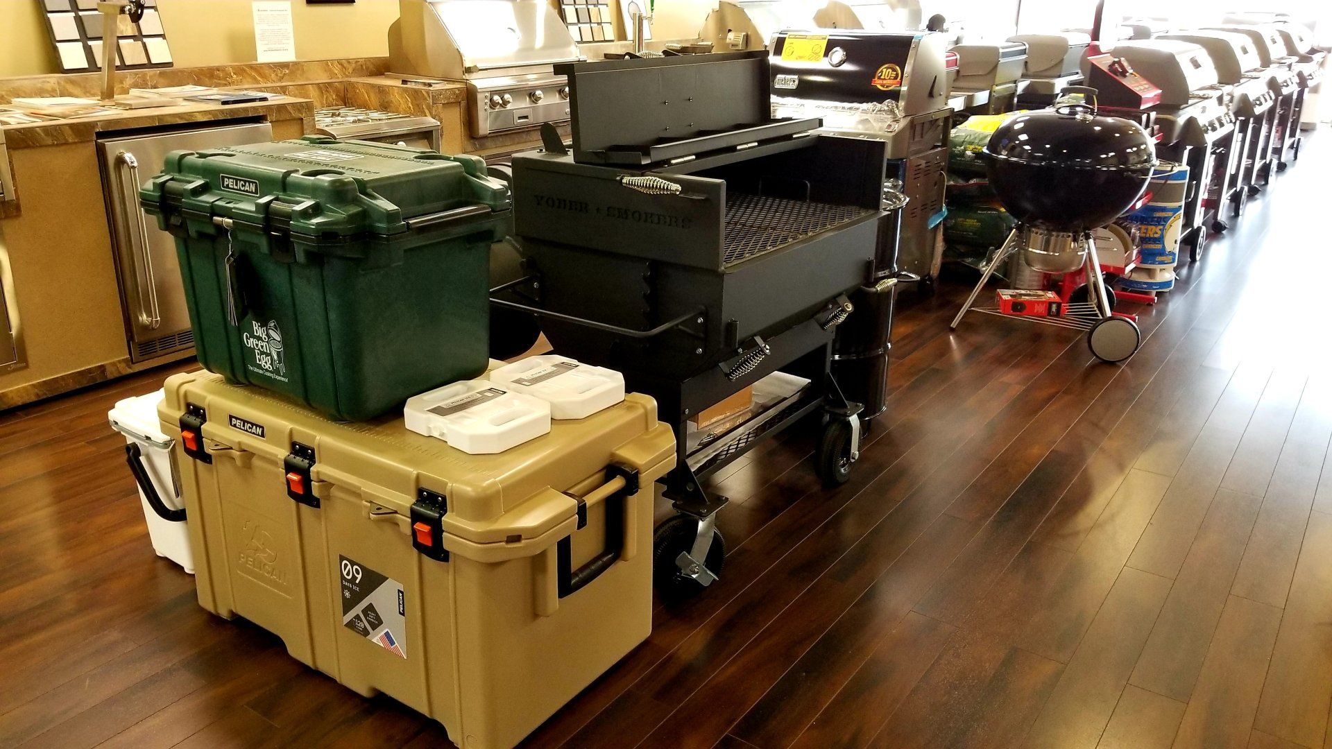 Coolers stacked inside a store with grills and other merchandise on display.