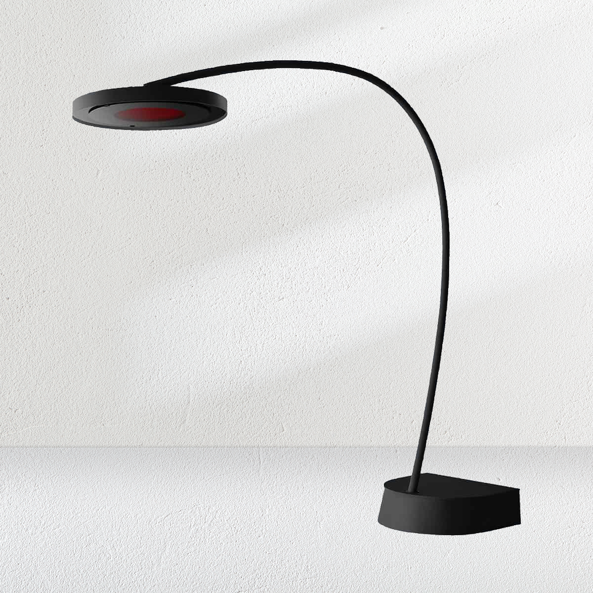 A black lamp with a flexible arm is sitting in front of a white wall