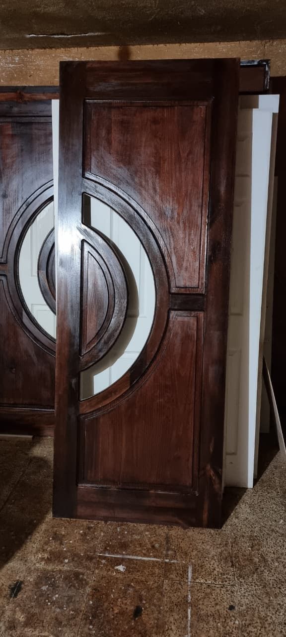 Armario de madera oscura con diseño circular de metal, colocado en el suelo del interior.