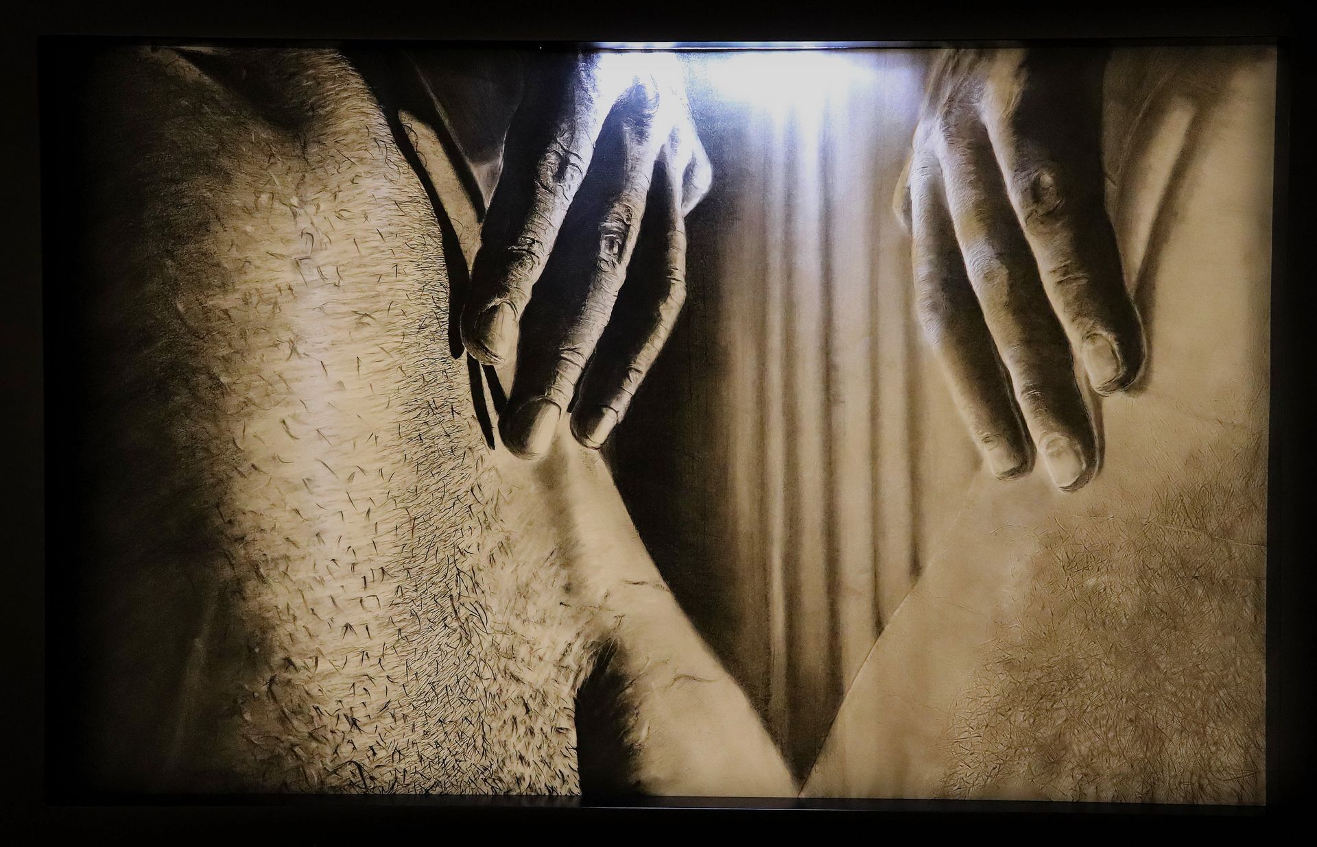 Sepia-toned close-up of two hands hovering over a person's torso, fingers slightly spread, suggesting intimacy.