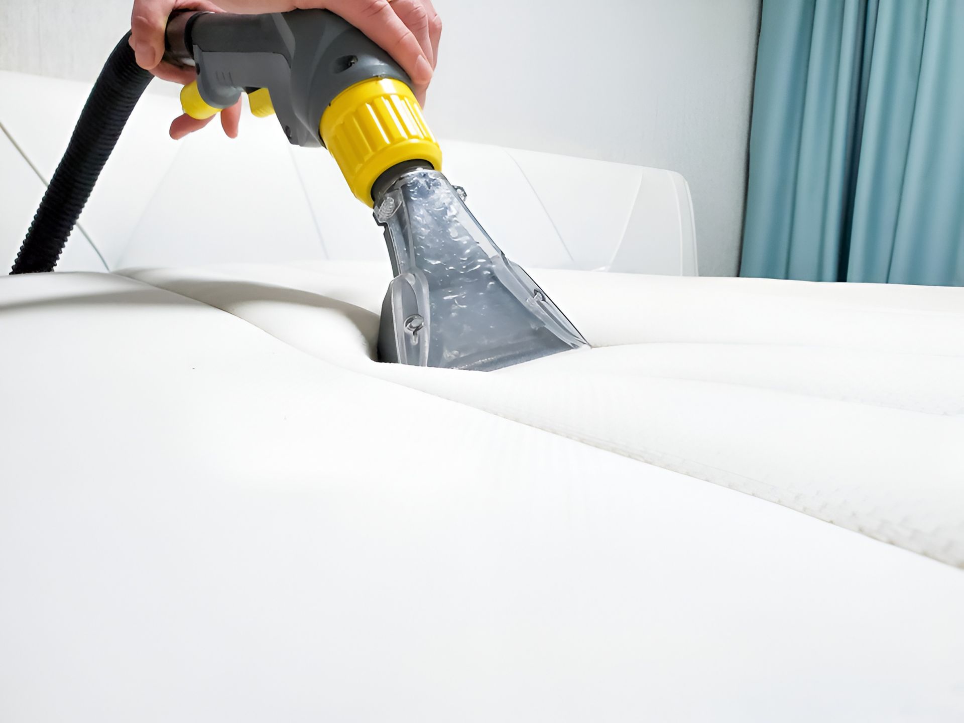 Person Cleaning a White Mattress — Kingaroy Carpet Cleaners in Kingaroy, QLD
