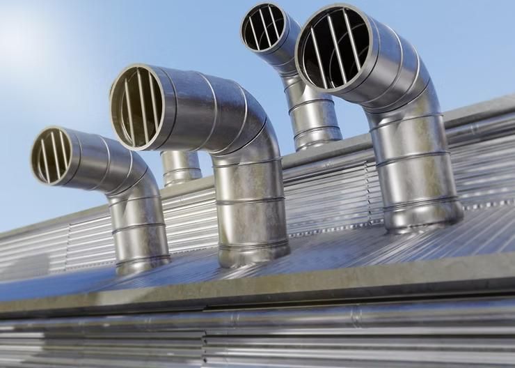 Metal ventilation pipes on a corrugated roof against a blue sky.