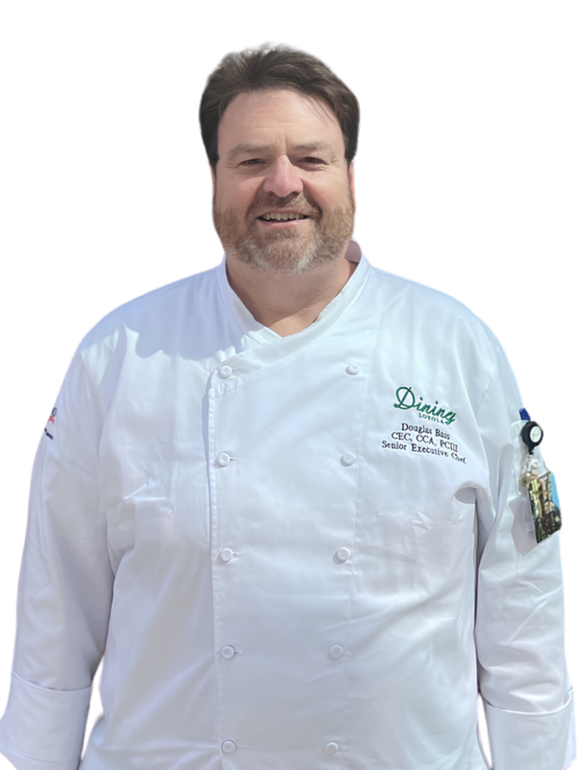 Chef with arms crossed, standing before a Loyola University logo.