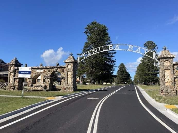 A road with a stone archway that says caniba bay