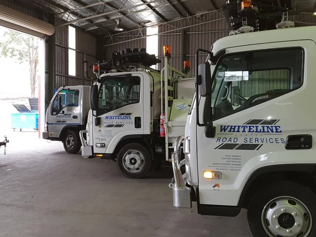 A Row of White Trucks Are Parked in a Garage | Beresfield, NSW | Whiteline Road Services