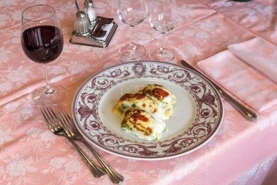 Tavolo da ristorante rustico vuoto con piatti e posate in una sala da pranzo scarsamente illuminata