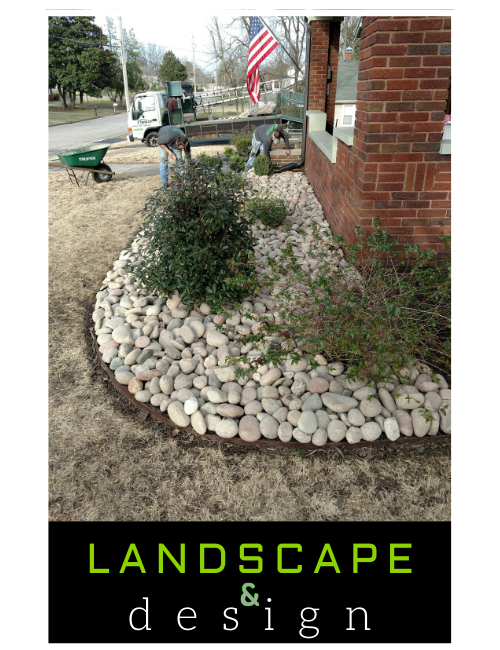 Landscape design sign beside a brick house with white rocks, plants, and an American flag