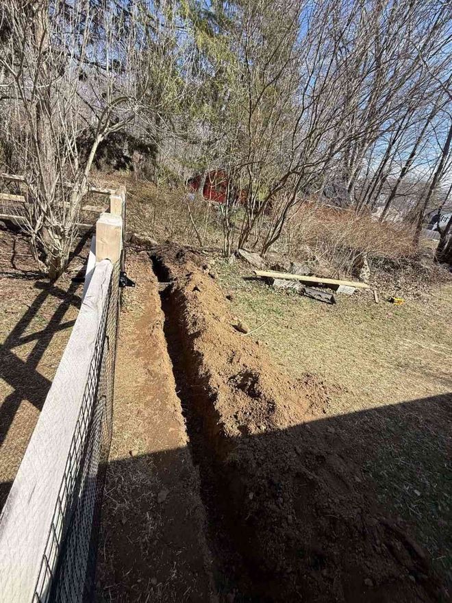French drain trench excavation along fence line on CT shoreline property
