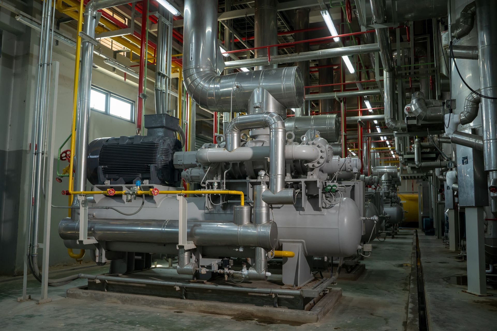Industrial machinery, gray and yellow pipes, in a factory setting.